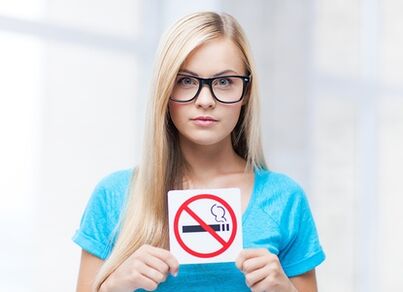 niña sosteniendo un cartel prohibición de fumar en la entrada